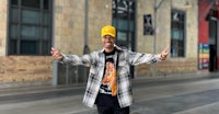 a man in a yellow hat standing in front of a building